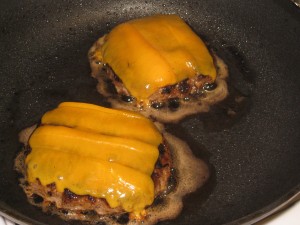 burgers in pan with melted cheese